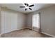 Bedroom featuring a ceiling fan, closet, carpet floors, and a bright window with curtains at 31920 Parkdale Dr, Leesburg, FL 34748