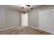 Neutral bedroom featuring carpet floors, a ceiling fan, and a double door closet at 31920 Parkdale Dr, Leesburg, FL 34748