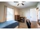 Well-lit bedroom featuring a comfortable bed, bookcase, and a desk, ideal for a workspace at 31920 Parkdale Dr, Leesburg, FL 34748