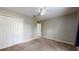 Neutral bedroom with ceiling fan, carpet flooring, and double door closet at 31920 Parkdale Dr, Leesburg, FL 34748