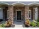 Stunning stone entryway with a black front door and manicured landscaping at 31920 Parkdale Dr, Leesburg, FL 34748