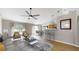 Staged living area with ceiling fan adjacent to kitchen with counter and bar seating at 31920 Parkdale Dr, Leesburg, FL 34748