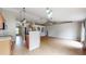 Open-concept living room and kitchen featuring wood-look floors, modern lighting, and stainless steel appliances at 31920 Parkdale Dr, Leesburg, FL 34748