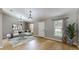The bright, staged living room features wood floors and two windows flanking the entry door at 31920 Parkdale Dr, Leesburg, FL 34748