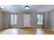 Bright living room featuring wood floors, neutral walls, and two windows flanking the entry door at 31920 Parkdale Dr, Leesburg, FL 34748