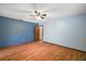 Spacious bedroom with blue walls, ceiling fan, and wood-look floors at 32132 Hickory Ln, Sorrento, FL 32776