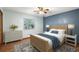 Stylishly furnished bedroom featuring a light wood frame bed, ceiling fan, and view from the window at 32132 Hickory Ln, Sorrento, FL 32776