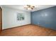 Bedroom with a blue accent wall, wood-look floors, and bright natural light from the window at 32132 Hickory Ln, Sorrento, FL 32776