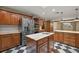 Bright kitchen features wood cabinets, stainless steel appliances, an island, and checkered floor, creating an inviting and modern space at 32132 Hickory Ln, Sorrento, FL 32776