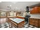 Spacious kitchen has wood cabinetry, stainless appliances, checkered floor, and marble island, perfect for entertaining and cooking at 32132 Hickory Ln, Sorrento, FL 32776