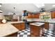 Well-lit kitchen with an island, granite countertops, dark cabinetry, and checkerboard flooring at 32132 Hickory Ln, Sorrento, FL 32776