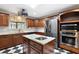 Spacious kitchen with stainless steel appliances, an island, and checkered flooring, offering a blend of style and functionality at 32132 Hickory Ln, Sorrento, FL 32776
