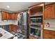 Well-equipped kitchen with stainless steel appliances, granite countertops, and wood cabinets, offering ample storage and cooking space at 32132 Hickory Ln, Sorrento, FL 32776