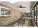 Enclosed patio with brick walls, ceiling fans, floor-to-ceiling windows, bar, and dining space at 32132 Hickory Ln, Sorrento, FL 32776