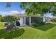 Well-maintained backyard showcasing a grill, manicured lawn, and screened in porch at 334 Shiloh Ct, The Villages, FL 32162