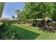 Well-manicured backyard features lush lawn, mature trees, and beautiful landscaping, offering a serene outdoor space at 334 Shiloh Ct, The Villages, FL 32162