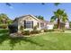 Attractive home boasts a lush green lawn, complemented by a mature palm tree and well-maintained landscaping at 334 Shiloh Ct, The Villages, FL 32162