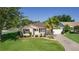 Charming single-story home with a well-manicured lawn, decorative driveway, and a lovely palm tree at 334 Shiloh Ct, The Villages, FL 32162
