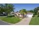 Charming single-story home with a well-manicured lawn, decorative driveway, and a lovely palm tree at 334 Shiloh Ct, The Villages, FL 32162