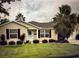 Charming single-story home with a well-manicured lawn and mature landscaping at 334 Shiloh Ct, The Villages, FL 32162