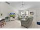 Cozy living room includes comfortable seating, a ceiling fan, and an airy feel with bright, natural light at 334 Shiloh Ct, The Villages, FL 32162