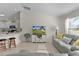 Bright living room featuring stylish seating, a large window, and an open view to the kitchen area at 334 Shiloh Ct, The Villages, FL 32162