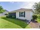 The home's rear exterior features a well-maintained lawn, screened-in porch, and charming landscaping at 334 Shiloh Ct, The Villages, FL 32162