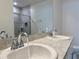 Elegant bathroom featuring double sinks, granite countertops, and a tiled shower with glass doors at 3638 Sw 127Th Lane Rd, Ocala, FL 34473