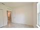 Well-lit bedroom with neutral walls, tile flooring, and a view into the attached bathroom at 3638 Sw 127Th Lane Rd, Ocala, FL 34473