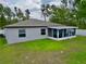 The rear view of this home showcases an enclosed lanai with a well-maintained lawn and landscaping at 3638 Sw 127Th Lane Rd, Ocala, FL 34473