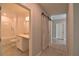 Hallway view highlighting modern barn door detail leading to a bathroom with a shower-tub combination at 3638 Sw 127Th Lane Rd, Ocala, FL 34473