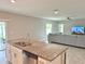 Modern kitchen featuring an island with granite countertops and stainless steel appliances overlooking the living room at 3638 Sw 127Th Lane Rd, Ocala, FL 34473