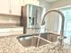 Close-up of the kitchen sink and faucet, highlighting granite countertops and stainless steel appliances at 3638 Sw 127Th Lane Rd, Ocala, FL 34473