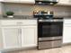 Modern kitchen featuring stainless steel appliances, granite countertops, and white cabinetry at 3638 Sw 127Th Lane Rd, Ocala, FL 34473