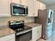 Close-up of kitchen featuring stainless steel appliances, granite countertops, and white cabinetry at 3638 Sw 127Th Lane Rd, Ocala, FL 34473