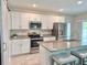 Modern kitchen featuring white cabinets, stainless steel appliances, granite countertops, and a center island with seating at 3638 Sw 127Th Lane Rd, Ocala, FL 34473