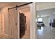 Modern laundry room with a stacked washer and dryer unit, barn door, and shelving at 3638 Sw 127Th Lane Rd, Ocala, FL 34473