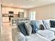 Cozy living room with a comfortable couch, view into the modern kitchen with bar seating, and natural light at 3638 Sw 127Th Lane Rd, Ocala, FL 34473