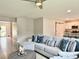 Living room with a comfortable sectional couch, a ceiling fan, and open access to the kitchen at 3638 Sw 127Th Lane Rd, Ocala, FL 34473