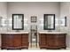 Bathroom with double vanities, large framed mirrors, and decorative sconces at 40050 Darlington Ave, Lady Lake, FL 32159