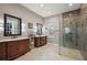Bathroom with marble tiling, glass enclosed shower, and double vanities with large framed mirrors at 40050 Darlington Ave, Lady Lake, FL 32159