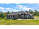 Charming home with a manicured lawn, a stone facade, arched windows, and a grand double door entrance at 40050 Darlington Ave, Lady Lake, FL 32159