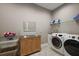 Bright laundry room featuring stainless steel countertops, modern washer and dryer, and ample storage shelving at 40050 Darlington Ave, Lady Lake, FL 32159