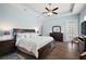 View of the main bedroom featuring hardwood floors, tray ceiling, ceiling fan, and a door leading to the outside at 40050 Darlington Ave, Lady Lake, FL 32159