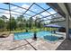 Gorgeous screened pool with brick pavers, lounge chairs, patio seating, and views of the backyard at 40050 Darlington Ave, Lady Lake, FL 32159