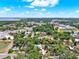An aerial view shows a home with a private pool and nearby lake and surrounding trees and commercial areas at 506 Perkins St, Leesburg, FL 34748