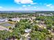 An aerial view shows a home with a private pool and nearby lake and surrounding trees at 506 Perkins St, Leesburg, FL 34748