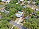 An aerial view shows a home with a private pool, nice landscaping and nearby lake and surrounding trees at 506 Perkins St, Leesburg, FL 34748