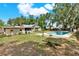 This backyard features a sparkling blue pool and a well-maintained lawn with mature trees at 506 Perkins St, Leesburg, FL 34748