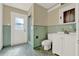 Vintage bathroom with green tile, a white vanity, and a walk-in shower at 506 Perkins St, Leesburg, FL 34748